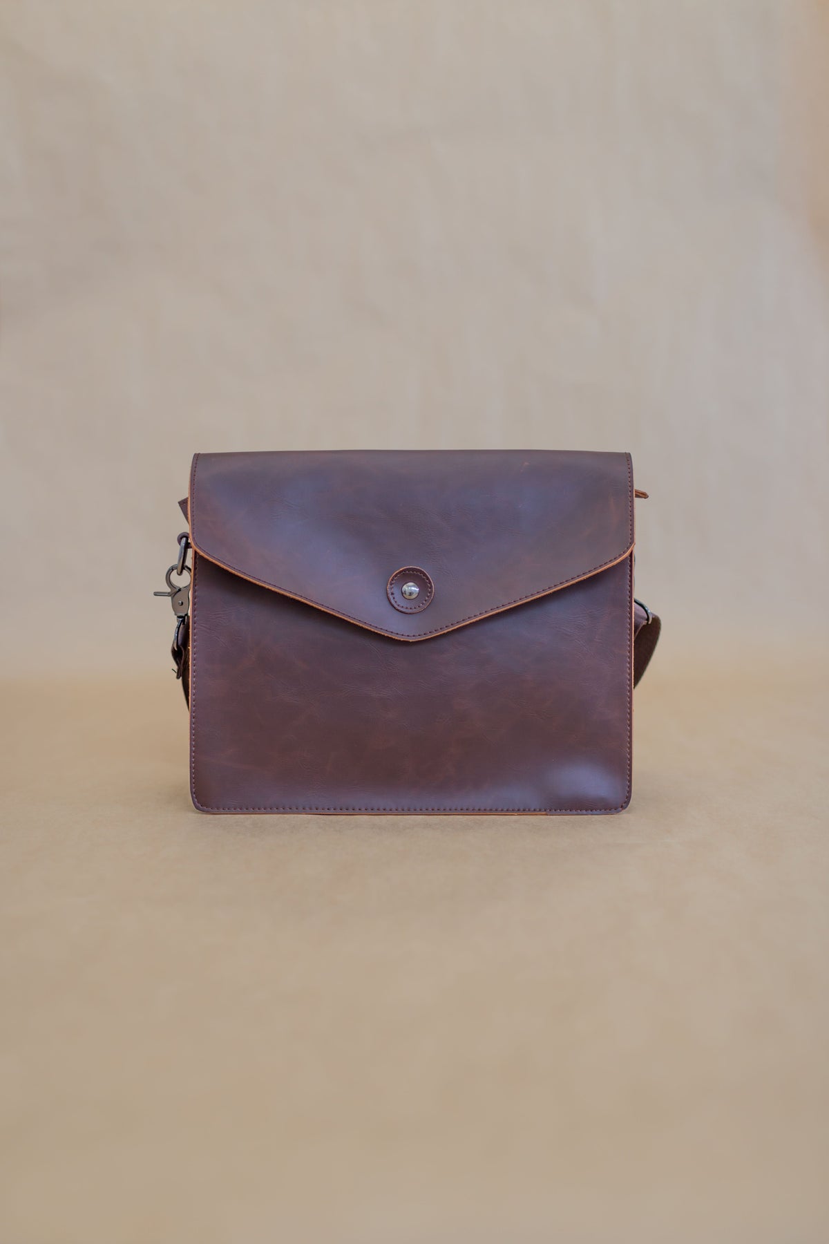 Real photographed brown leather handbag on neutral background