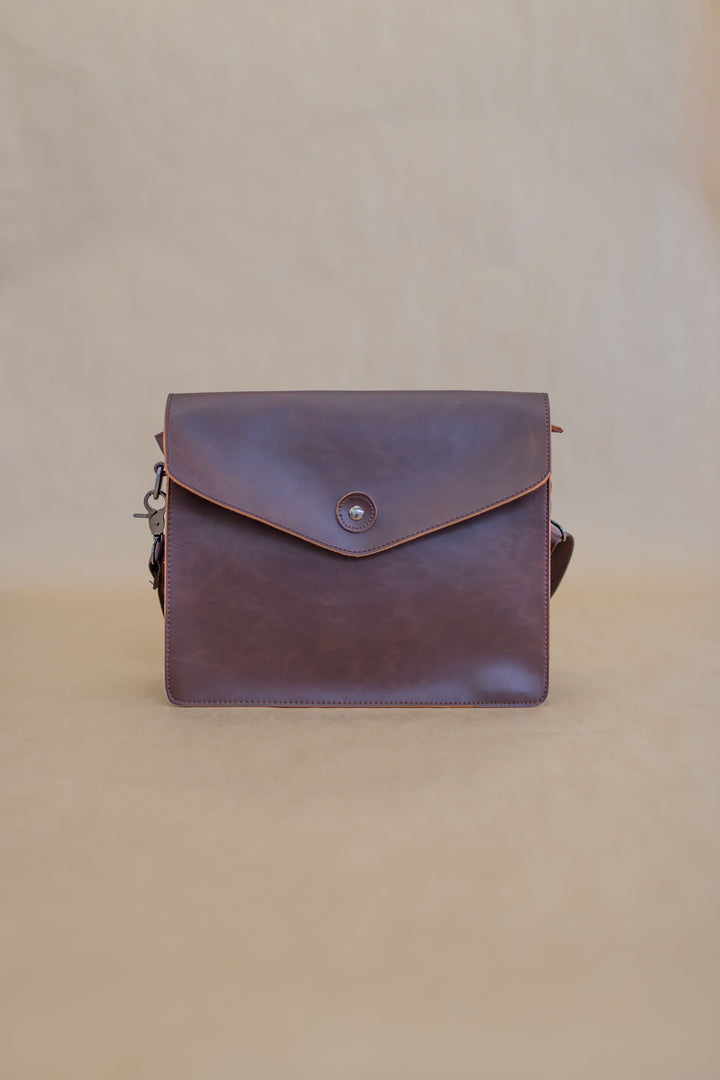 Real photographed brown leather handbag on neutral background